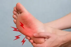 3 Common Types of Peripheral Neuropathy - Close-up image of a person holding the sole of their foot, showing red lightning symbols indicating pain from diabetic peripheral neuropathy